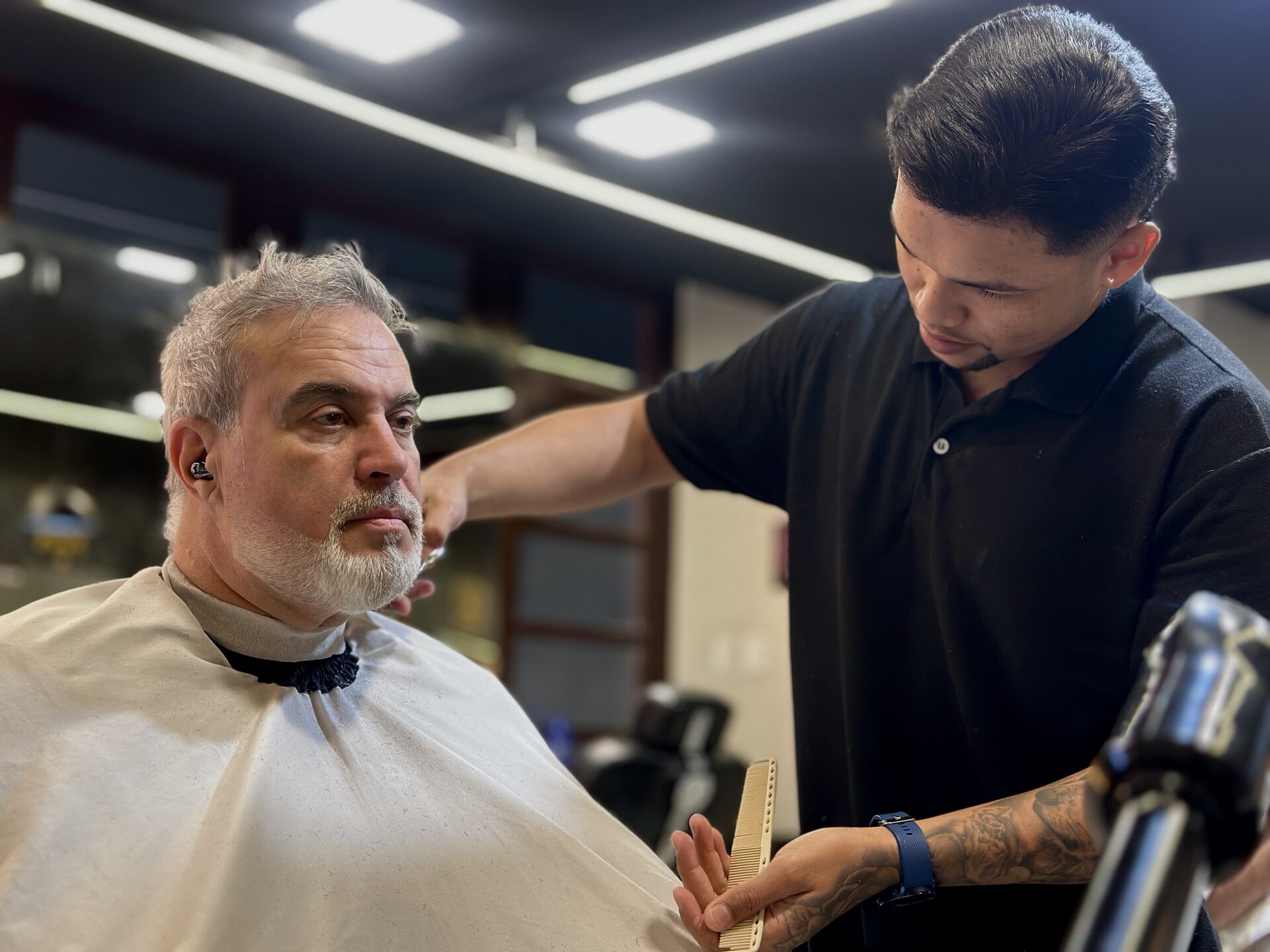 Barbeiro em Fortaleza realizando corte preciso na Delta Barbearia
